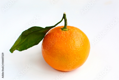 Ripe juicy tangerine with leaves on a white background.