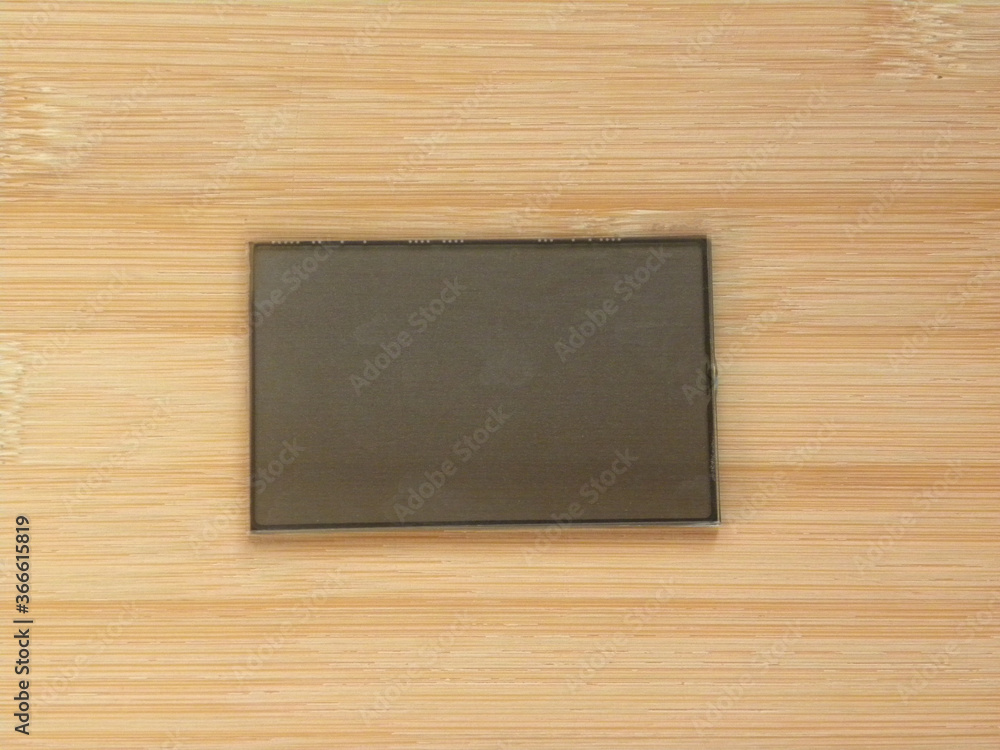 Small gray color digital display LCD screen kept on wooden table Small gray color digital display LCD screen kept on wooden table