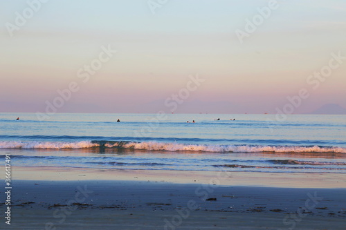Fototapeta Naklejka Na Ścianę i Meble -  Flat empty ocean with calm waves in the sunset. Itaguare beach, Bertioga, Brazil 