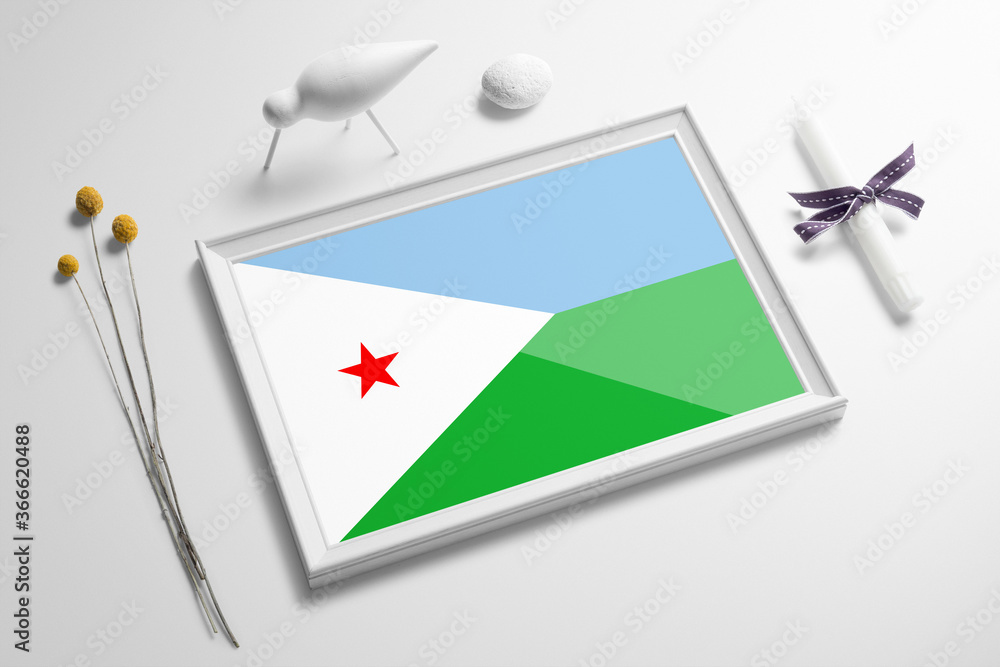 Djibouti flag in wooden frame on table. White natural soft concept, national celebration theme.
