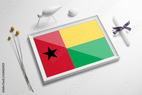 Guinea flag in wooden frame on table. White natural soft concept, national celebration theme.