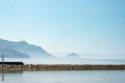 A pier standing on the sea with islands looked over there