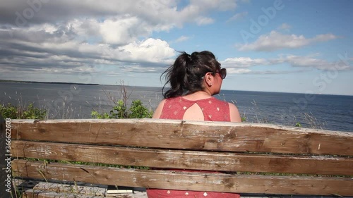 Woman enjoying peaceful ocean park bench