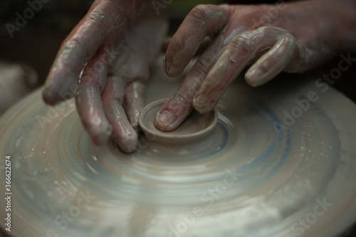 Potter at work. Hands sculpt clay. Creation of dishes.