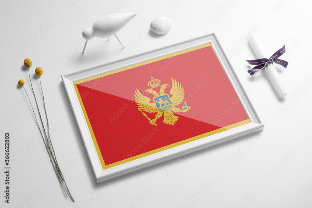 Montenegro flag in wooden frame on table. White natural soft concept, national celebration theme. Montenegro flag in wooden frame on table. White natural soft concept, national celebration theme.