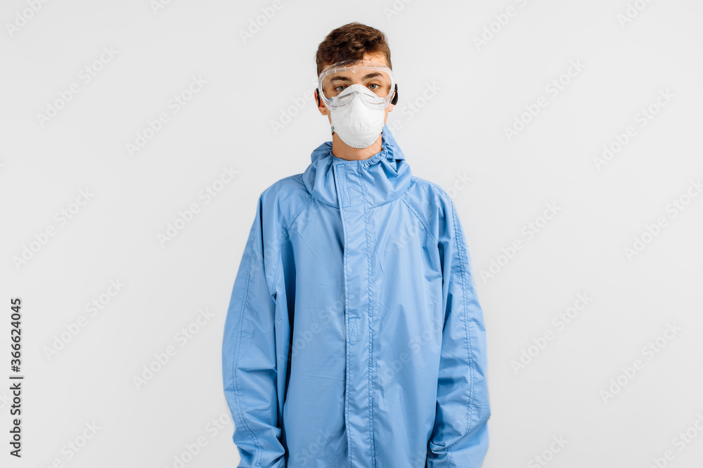 male doctor dressed in a protective suit against coronavirus, wearing a medical mask, glasses and gloves, on an isolated white background. Quarantine, coronavirus male doctor dressed in a protective suit against coronavirus, wearing a medical mask, glasses and gloves, on an isolated white background. Quarantine, coronavirus