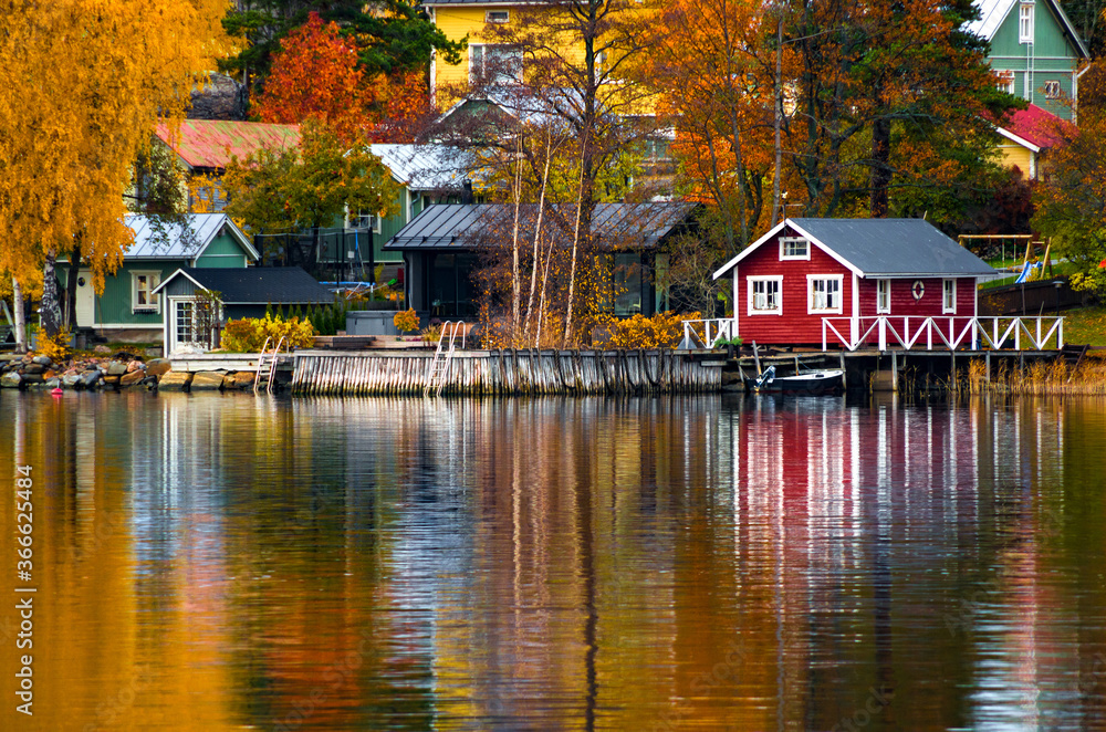 Colorful houses and trees reflecting in the water surface. Autumn in Rauma, Finland.