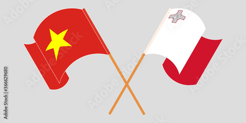 Crossed and waving flags of Malta and Vietnam