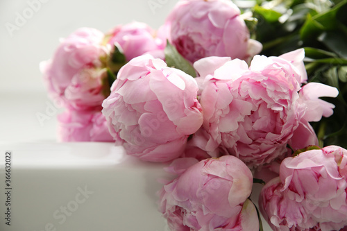 Bouquet of beautiful pink peonies on counter in kitchen, closeup