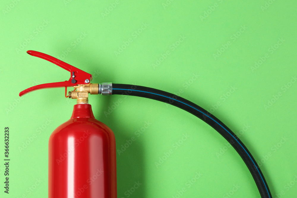 Fire extinguisher on green background, top view Fire extinguisher on green background, top view