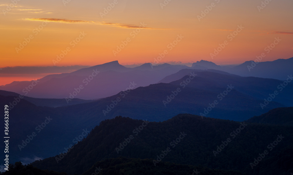 Mountain landscape in the early morning before sunrise with orange and purple sky Mountain landscape in the early morning before sunrise with orange and purple sky