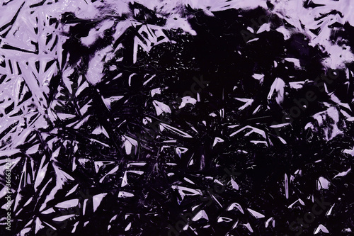 Auf gefrorenem Wasser ist ein abstraktes Muster in schwarz und lila entstanden 