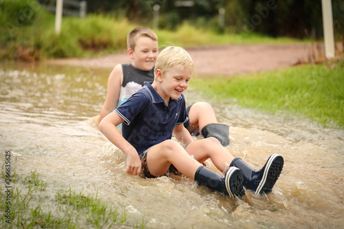 Happy kids playing in floodwater on rainy day