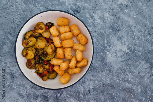 plant-based food, sauteed mediterranean vegetables with soy sauce and wir fried potato royals photo