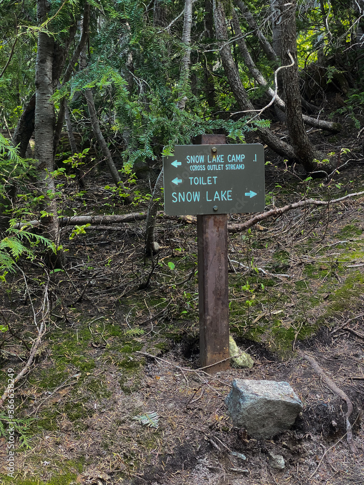 Trail marker pointing to outdoor toilet