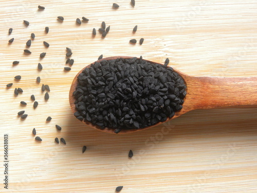 Black caraway or Nigella sativa seeds on wooden spoon photo