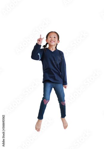 Smiling asian child girl jumping on air with showing two finger gesture as sign as fighting isolated on white background