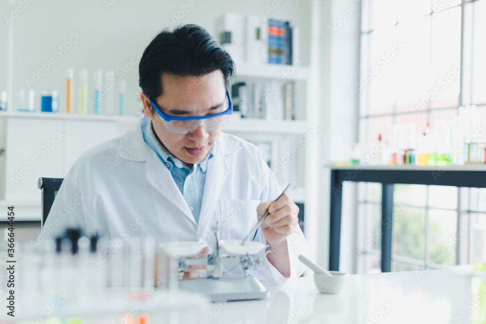 Asian scientists are preparing plant-based materials for testing and analysis in the laboratory. Scientists clear glasses and white shirts. Science and Chemistry Concept Asian scientists are preparing plant-based materials for testing and analysis in the laboratory. Scientists clear glasses and white shirts. Science and Chemistry Concept