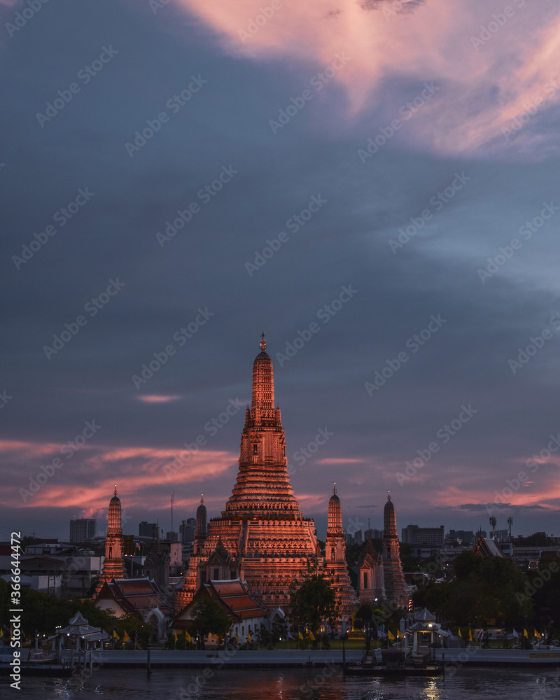 Fototapeta premium Templo Wat Arun al atardecer con el cielo lleno de nubes