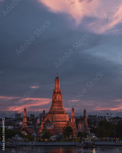 Templo Wat Arun al atardecer con el cielo lleno de nubes