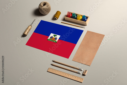 Haiti calligraphy concept, accessories and tools for beautiful handwriting, pencils, pens, ink, brush, craft paper and cardboard crafting on wooden table. photo