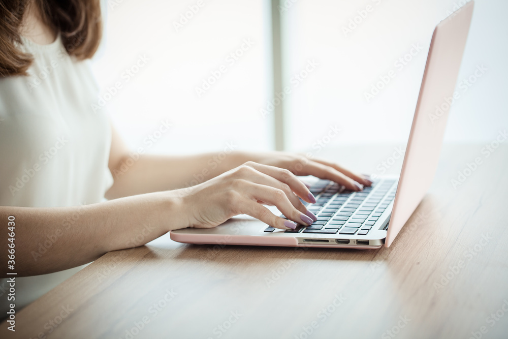 Naklejka premium Beautiful young woman hands typing on a laptop