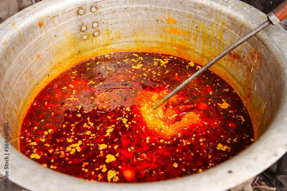 Masala spicy sauce prepared in large pot in Indian village