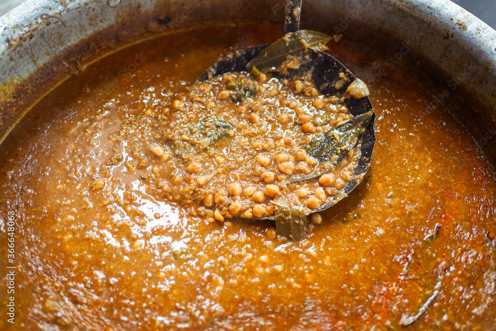 Large pot with chickpeas and brown sauce prepared in Indian village