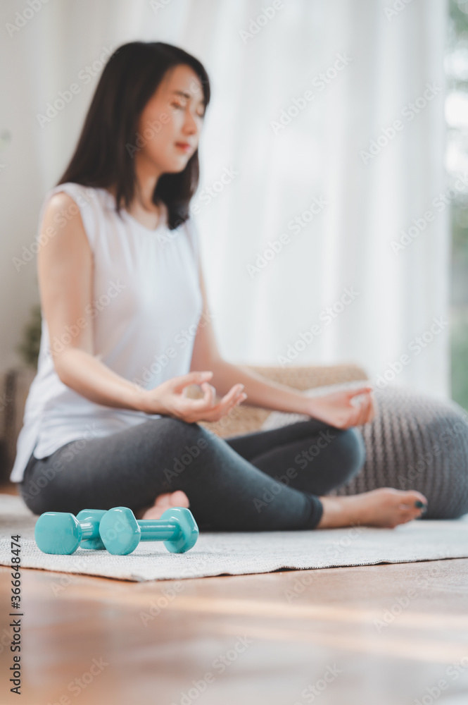 dumbbell on the floor with woman doing meditation