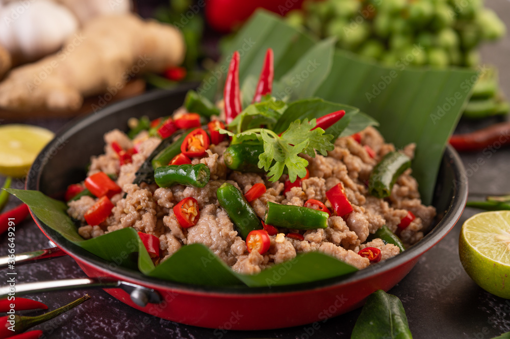 Stir-fried pork basil on banana leaves in a frying pan. Stir-fried pork basil on banana leaves in a frying pan.