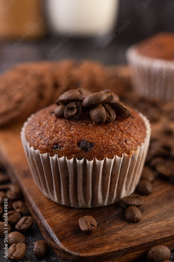 Banana cupcakes that are placed on a wooden plate with coffee grains. Banana cupcakes that are placed on a wooden plate with coffee grains.