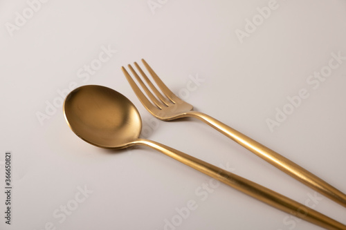 Golden spoon and fork isolated on white background