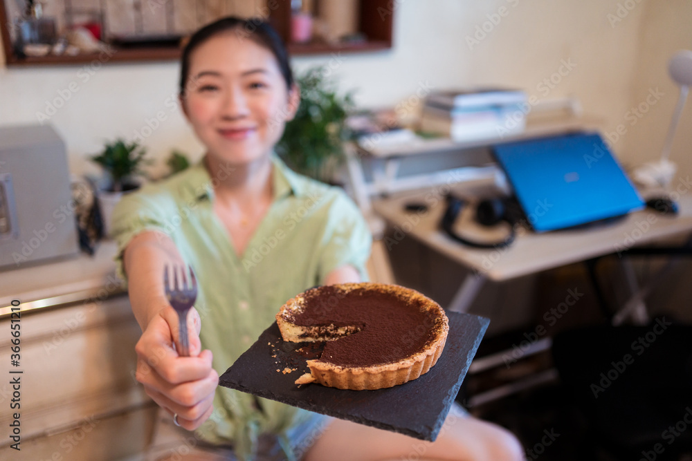 A top view of a delicious chocolate tart with mint on top being prepared by hand
