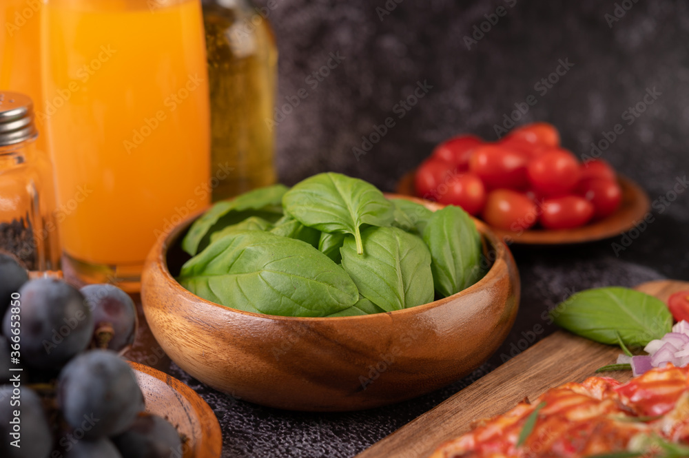 Thyme and tomatoes in a wooden cup with garlic on a wooden chopping board. Thyme and tomatoes in a wooden cup with garlic on a wooden chopping board.