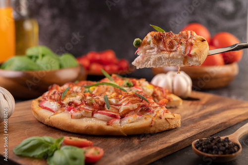 pizza placed on a wooden plate.