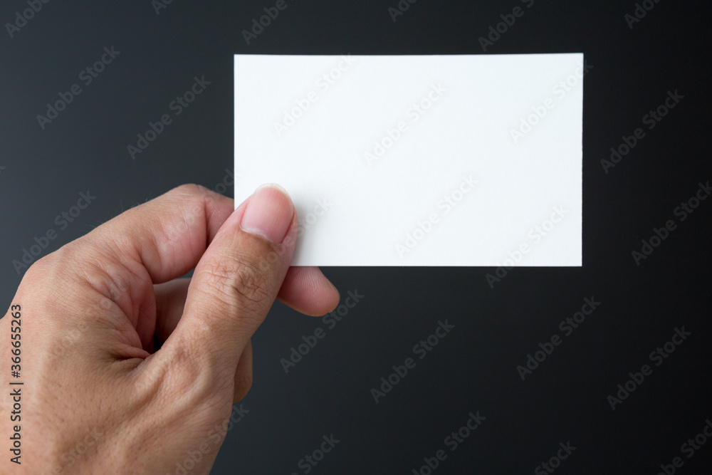Hand holding Business card on a black background Hand holding Business card on a black background