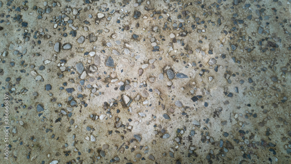 Grey concrete background made of small pebbles . Gravel, concrete wall