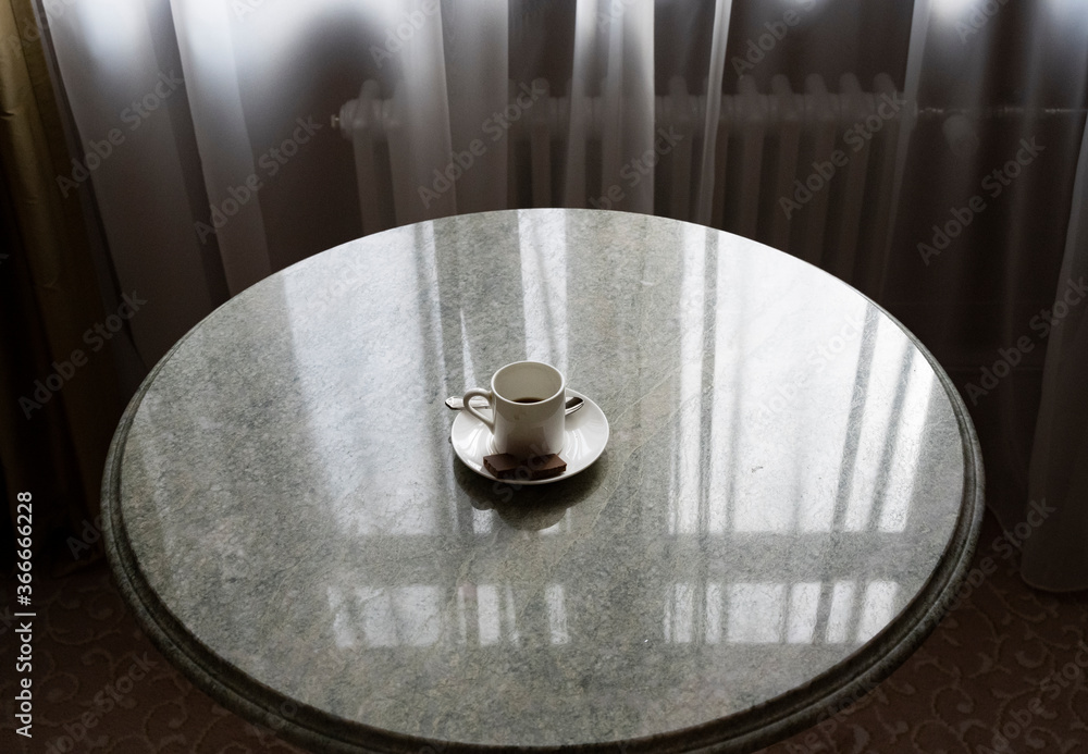 cup of morning coffee on a round marble table with different items cup of morning coffee on a round marble table with different items