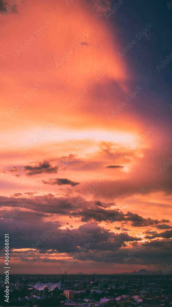 Fototapeta premium beautiful sunset with cloudy skies over the city and mountains 