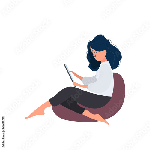 The girl is sitting on an ottoman with a tablet. A woman with a tablet is sitting on a large pouf. Isolated. Vector.