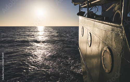 Stern of an old ship at sunset, travel or homesickness concept.