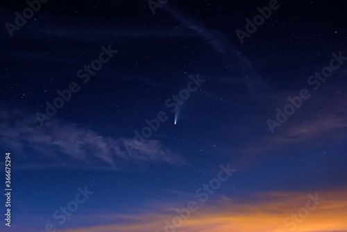 Neowise comet on dark cloudy starry sky at dusk