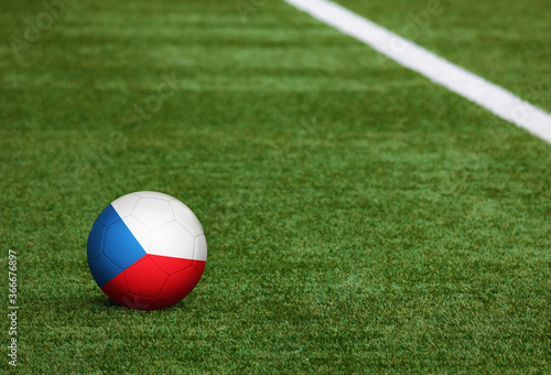 Czech Republic flag on ball at soccer field background. National football theme on green grass. Sports competition concept.