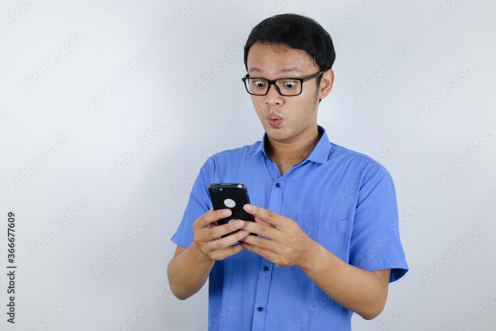Fototapeta premium Young asian man shocked and happy when he looking smartphone