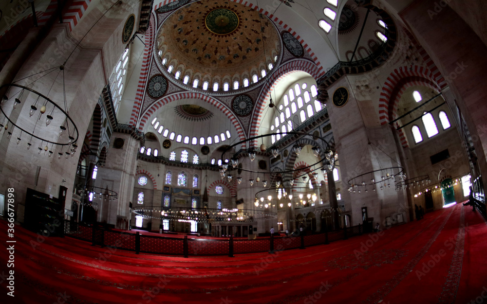 View into the interior of the Süleymaniye Mosque in Istanbul, with domes, prayer room, windows and numerous calligraphies.