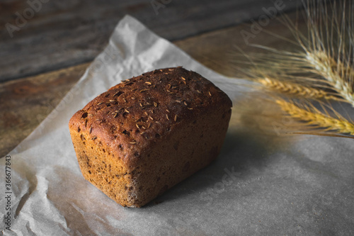 loaf of bread with sesame seeds on wooden background