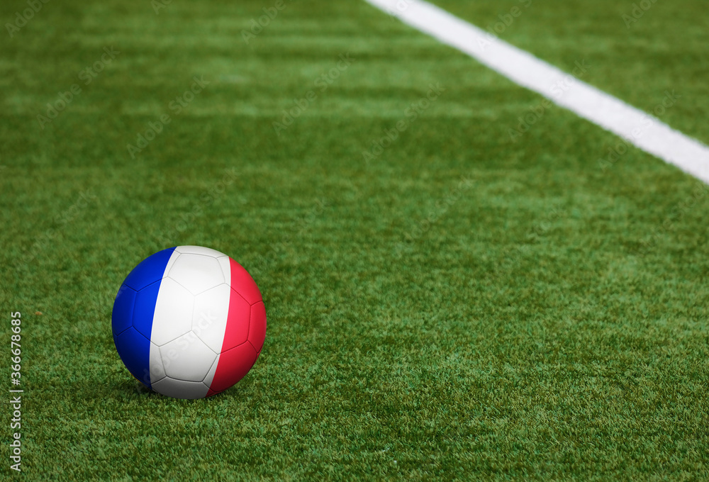 France flag on ball at soccer field background. National football theme on green grass. Sports competition concept. France flag on ball at soccer field background. National football theme on green grass. Sports competition concept.