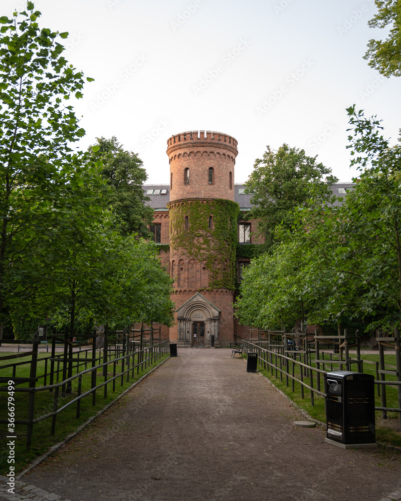 View through park towards medieval building Kungshuset (Kings house) in Lund, Sweden
