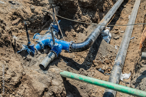 Water pipes in the trench. Water supply distribution manifold. © Viktor