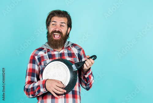 cooking utensils vessels. kitchen advertising. Man with saucepan. Man hold new brand pan. Shopping kitchenware. cooking pot in cook man hands in kitchen. food preparation and cuisine